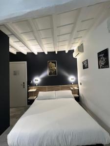 آي رومز - سبنش ستيبس في روما: سرير أبيض كبير في غرفة نوم بجدران سوداء