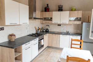 uma cozinha com armários brancos e um forno com placa de fogão em Spacious and cozy beachfront villa em Grand-Popo