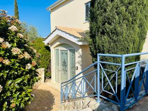 a house with a blue door and some bushes at Beach Villa Elena in Polis Chrysochous