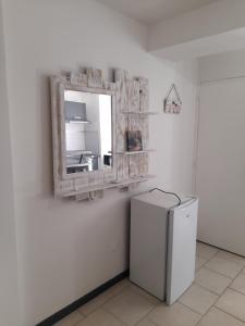 uma cozinha com um frigorífico e um espelho na parede em Chez Sabine et Patrick em Narbona