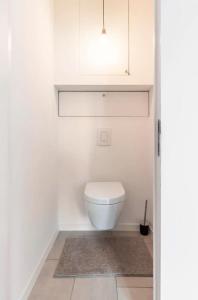 a bathroom with a white toilet and a rug at New apartment with big terrace and great views! in Leuven