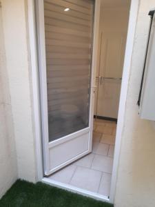 uma porta de vidro deslizante para um chuveiro na casa de banho em Chez Sabine et Patrick em Narbona