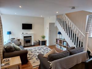 CanonbieにあるThe Coach House, Canonbieの2つのソファと暖炉のあるリビングルーム +21枚の写真