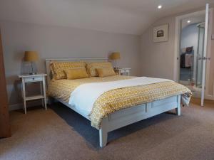 a bedroom with a bed and two tables with lamps at The Coach House, Canonbie in Canonbie