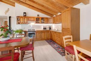 une cuisine avec des placards en bois et une table ainsi qu'une salle à manger dans l'établissement Casa Sergio, à Grosio