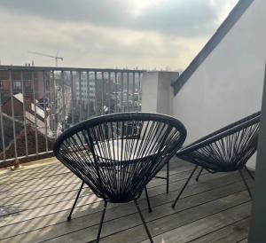 two chairs on a balcony with a view of a city at New apartment with big terrace and great views! in Leuven