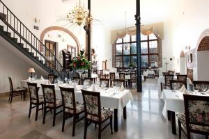 une salle à manger avec des tables et des chaises blanches dans l'établissement Kadyny Folwark Hotel & SPA, à Kadyny