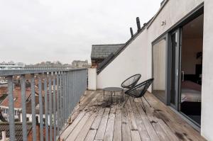 a patio with two chairs and a table on a deck at New apartment with big terrace and great views! in Leuven