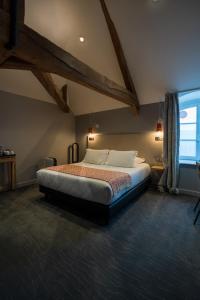 een slaapkamer met een groot bed op zolder bij Hôtel Loysel le Gaucher in Montreuil-sur-Mer