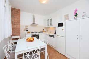 a kitchen with white appliances and a table with a bowl of fruit at Apartment Piano in Dubrovnik +37 photos