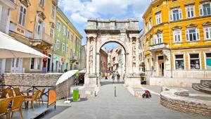 an arch in the middle of a street with buildings at Central apartments in Pula