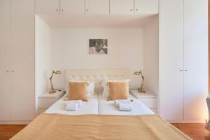 リスボンにあるCasa Portuguesa Chiadoの白いベッドルーム(大型ベッド1台、ナイトスタンド2台付)