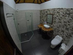 a bathroom with a shower and a toilet and a sink at EcoHostal Rio Piedra in El Zaino +66 photos