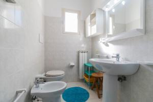 Un baño blanco con lavabo e inodoro. en Suite Apartment La Punta, en Cala Gonone