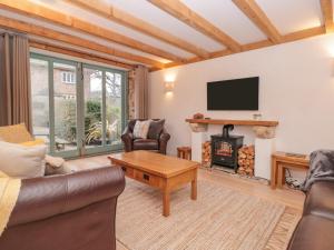 - un salon avec un canapé et une cheminée dans l'établissement 1 Alston Farm Cottages, à Brixham