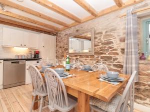 uma cozinha e sala de jantar com uma mesa de madeira e cadeiras em 1 Alston Farm Cottages em Brixham