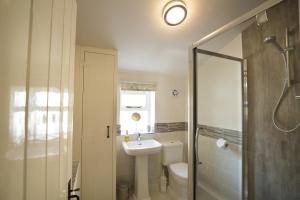 a bathroom with a sink and a toilet and a shower at Bramwood Cottages in Pickering