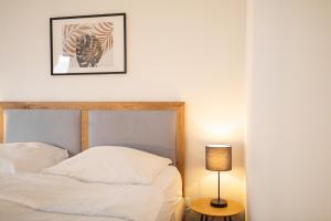 ein Schlafzimmer mit einem Bett und einem Bild an der Wand in der Unterkunft Koje Fünf I Apartment in Stadtmitte mit Hafenblick in Bremerhaven