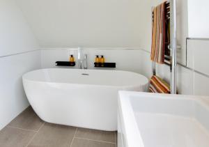 a white bath tub in a white bathroom at Beech Corner in Cawston