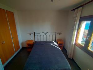 a bedroom with a bed with two tables and a window at Habitacion en casa particular con vista al mar in Cala del Moral