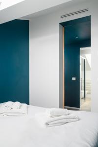 um quarto com uma cama branca e toalhas em Design Attic porta venezia centrale 65m2 - self check-in em Milão