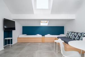 una stanza con due letti, un tavolo e delle sedie di Design Attic porta venezia centrale 65m2 - self check-in a Milano