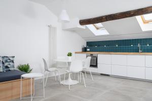 uma cozinha com armários brancos e uma mesa e cadeiras em Design Attic porta venezia centrale 65m2 - self check-in em Milão