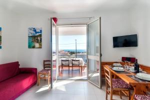 a living room with a red couch and a table at Suite Apartment La Punta in Cala Gonone