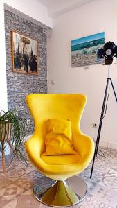 una sedia gialla con un cuscino sopra in una stanza di Casa Princesa Huelin a Málaga