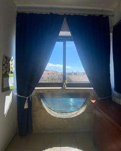 una ventana con una cortina azul en una habitación en Villa Ignoto, en Bale