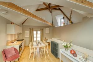 a kitchen and living room with a table and chairs at Hôtel Loysel le Gaucher in Montreuil-sur-Mer