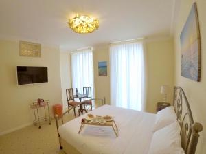 ein Schlafzimmer mit einem weißen Bett und einem Kronleuchter in der Unterkunft Palazzo Florio Boutique Residence in Vasto