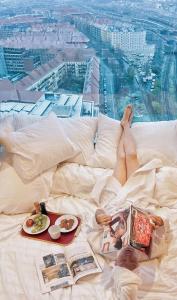 eine Person, die auf einem Bett mit einem Teller Essen liegt in der Unterkunft Bohr Apartment Copenhagen in Kopenhagen
