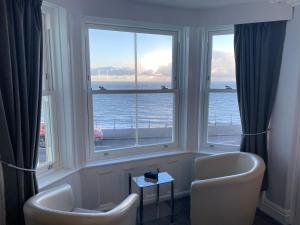 a room with two chairs and a large window at Marine View Guest House in Scarborough
