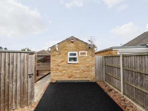 a brick house with a fence and a driveway at Lockdown Lodge in Mablethorpe