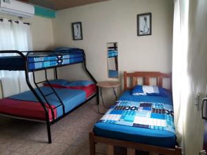 a bedroom with two bunk beds and a table at Oceans Hostal in Santa Catalina