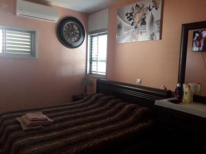una camera con un letto e un orologio a muro di Private room in the сomfortable apartment in Ashdod, 7 min walk to the beach a Ashdod