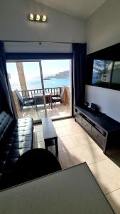 uma sala de estar com um sofá e uma televisão de ecrã plano em DELUXE SeaView-SUNSETS !TRANSFE-R inc! POOL,2AirCond,2TV65",600Mb Dishwasher,,2 BEACHes,ANFI-view em Patalavaca