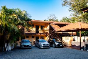 drie auto's geparkeerd voor een huis bij Roxy's Bed & Breakfast in Boca Chica