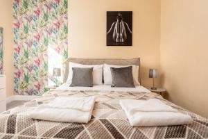 um quarto com uma cama grande e 2 almofadas em Briarhill - Donnini Apartments em Prestwick