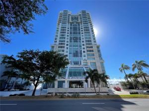 KASA Skyview Luxury Loft Style 15th floor Condo في سان خوان: مبنى ابيض طويل عليه ساعه