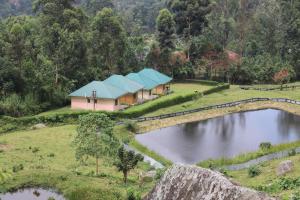 a house on a hill next to a lake at Snow Valley Cottages in Kasese