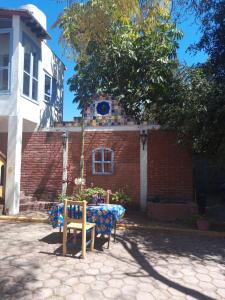 a table and a chair in front of a brick building at La lagartija in San Pablo Etla