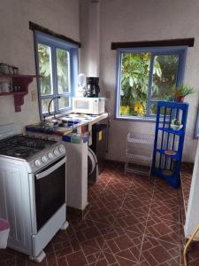 a kitchen with a stove and a sink and a microwave at La lagartija in San Pablo Etla