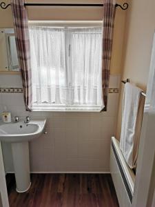 ein Bad mit einem Waschbecken und einem Fenster in der Unterkunft Town House B & B in Skipton
