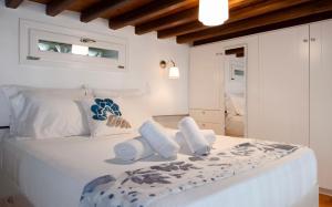 a bedroom with a large white bed with towels on it at Apanemo in Faros