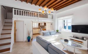 a living room with a white couch and a tv at Apanemo in Faros