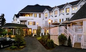 a large white building with a car parked in front of it at Wolfeboro Inn in Wolfeboro