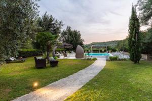 a garden with a swimming pool in the background at Villa Veranda, a Romantic Farmhouse with Pool in Larciano