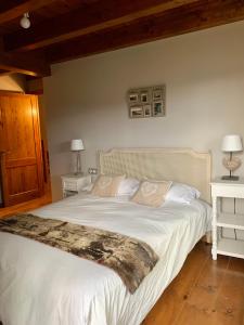 1 dormitorio con 1 cama grande con sábanas y almohadas blancas en Casa en Estavar Residential con jardín y piscina, en Estavar